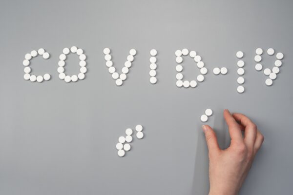 The words 'Covid-19' spelled out in tablets