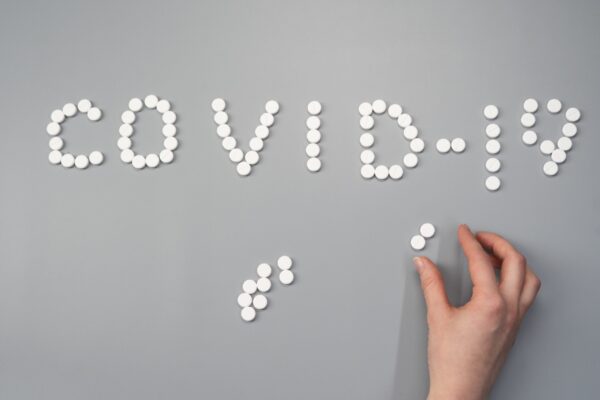 The words 'Covid-19' spelled out in tablets